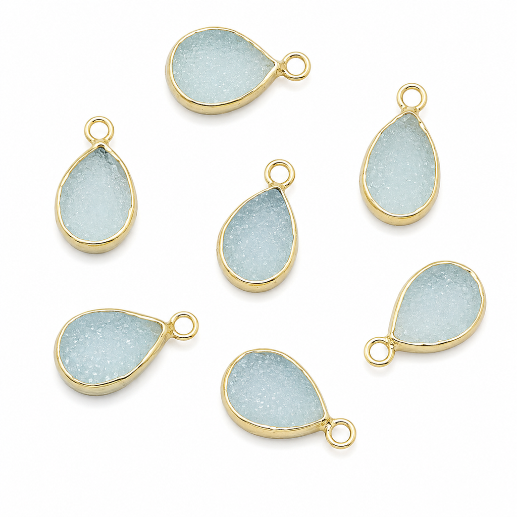 Aqua druzy teardrop charms in gold settings on a white background