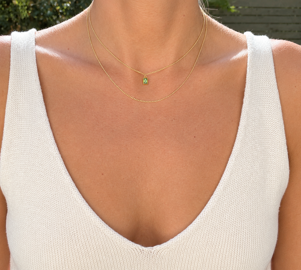 The Birthstone Bezel Layered Necklace worn with a green birthstone