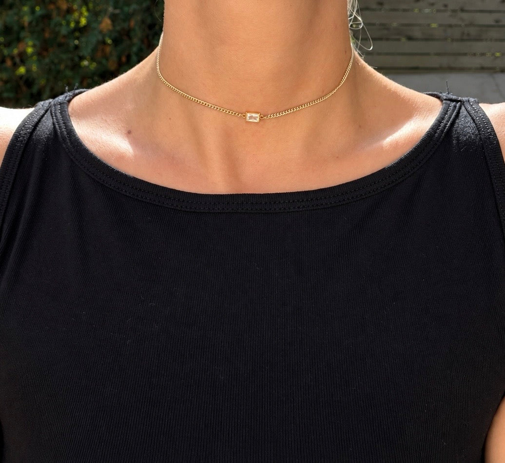 The Birthstone Bezel Necklace worn with a clear rectangular stone