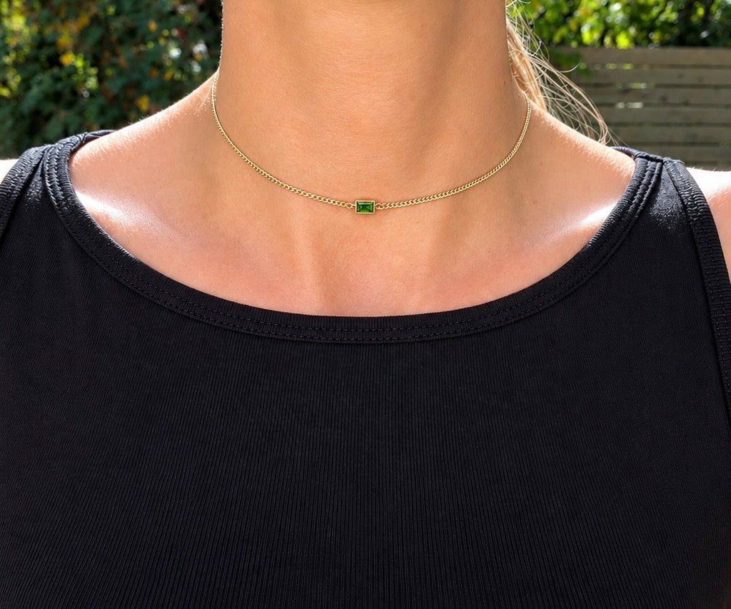 The Birthstone Bezel Necklace worn with a green rectangular stone