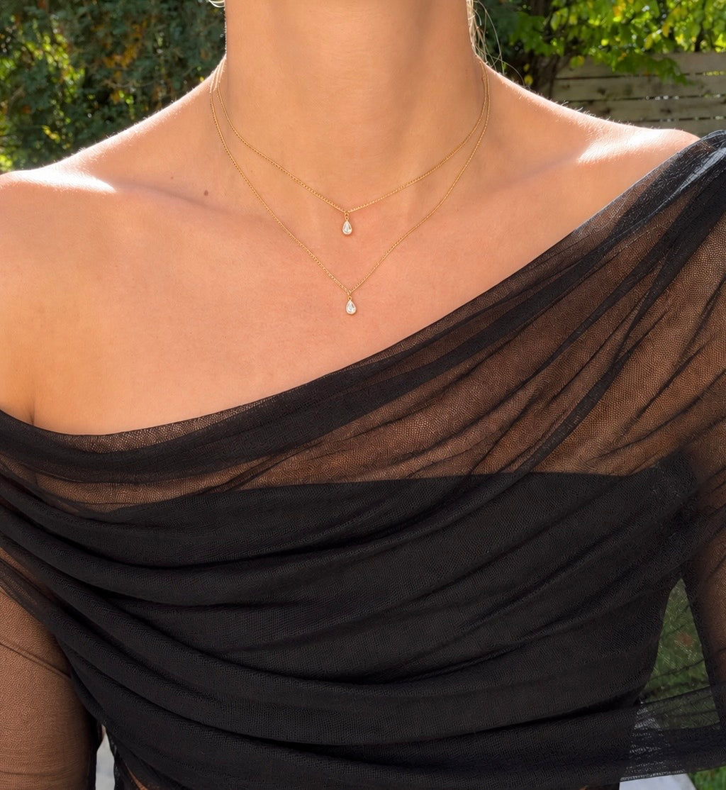 The Layer Necklace worn with two delicate gold chains and pear-shaped stones