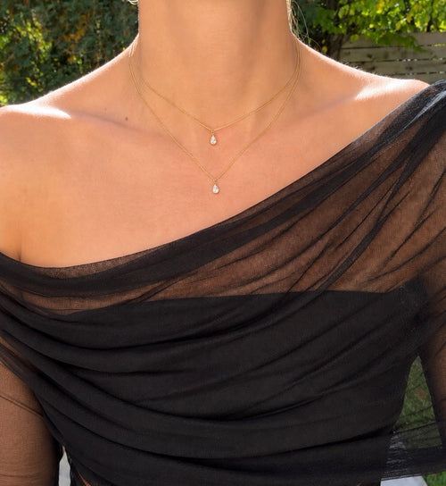 The Layer Necklace worn with two delicate gold chains and pear-shaped stones
